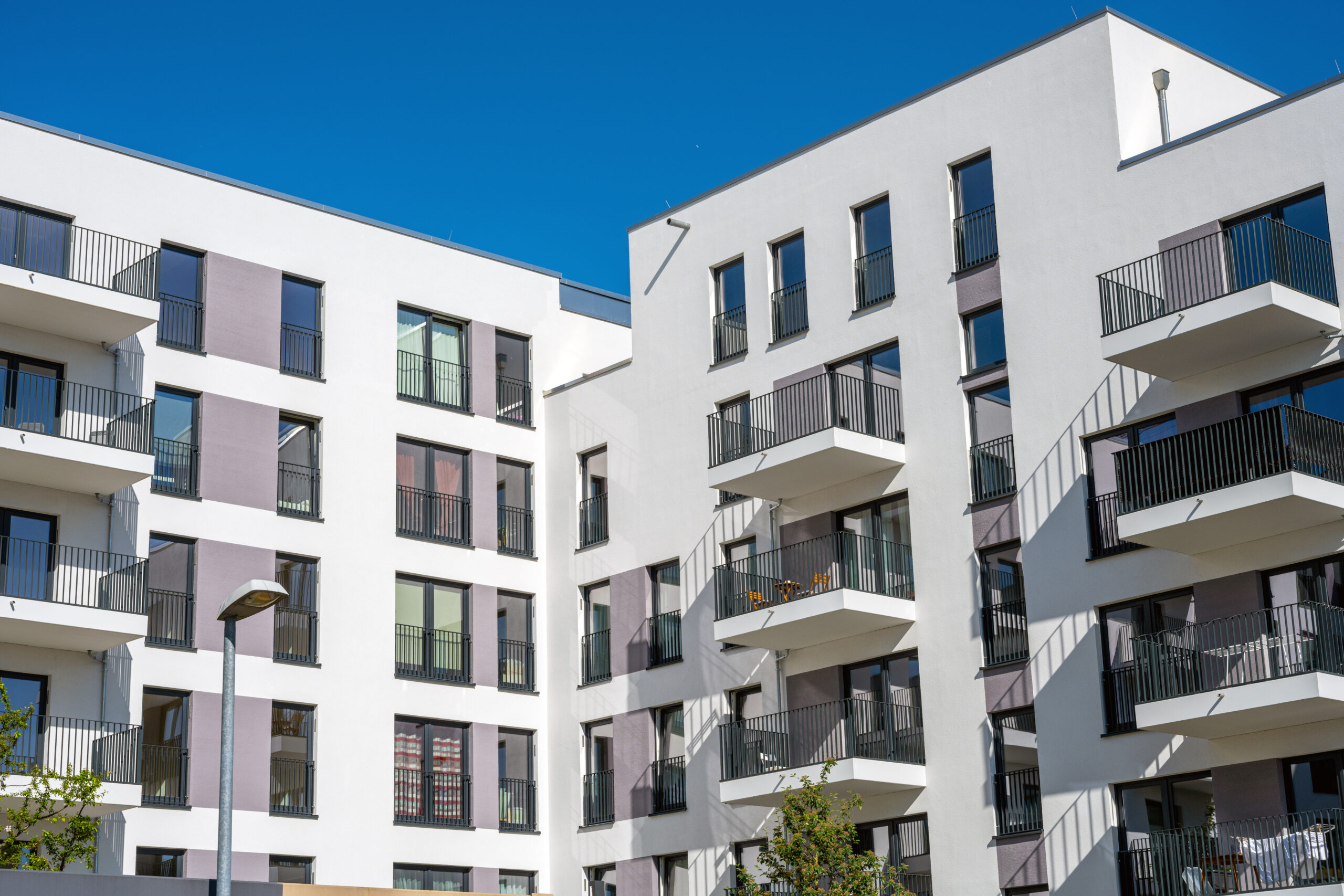 Helles Mehrfamilienhaus mit Balkonen – Symbolbild für Wohnimmobilien